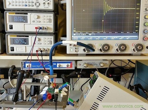 图3：用于DC/DC转换器的完整仪器设置展示。测试板输入电压调节至12V，栅极驱动调节器供电电压为7V。右下方显示了负载，Keysight 90000-X示波器、Teledyne Lecroy PP066传输线探头和Huber Suhner Sucoflex 100电缆等也都可以在图上看见。